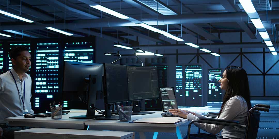 Two people in the control center of what could be a power substation