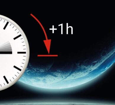 Imagen estilizada de un reloj MOBATIME sobre un fondo que representa el espacio exterior, con una flecha marcada en rojo y el texto "+1h" que indica un cambio de hora.